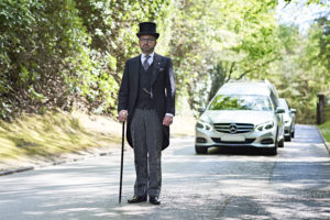 funeral director leading a hearse